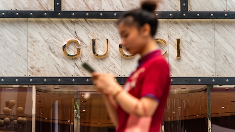 Shopper walking past the Gucci store in Jiefangbei, Chongqing, China. Image credit: Shutterstock, Vincent Nguyen